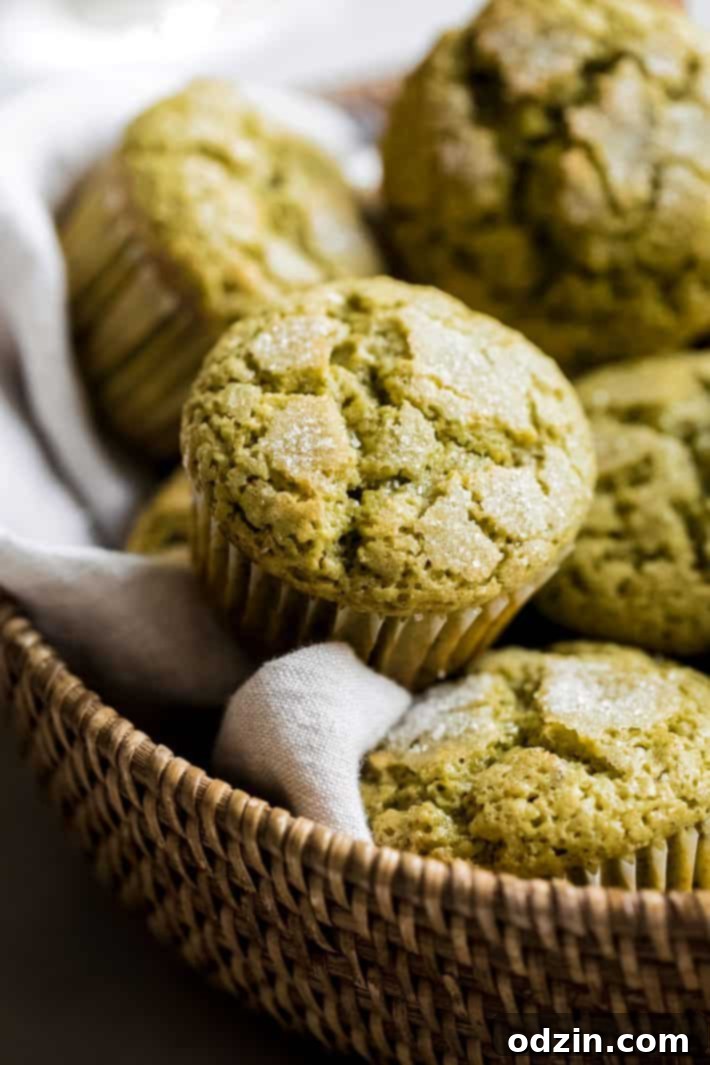 Perfectly Pistachio Muffins: Bakery Quality, Pudding-Free 6 A single baked pistachio muffin in a brown tulip liner, sitting in a wooden basket.