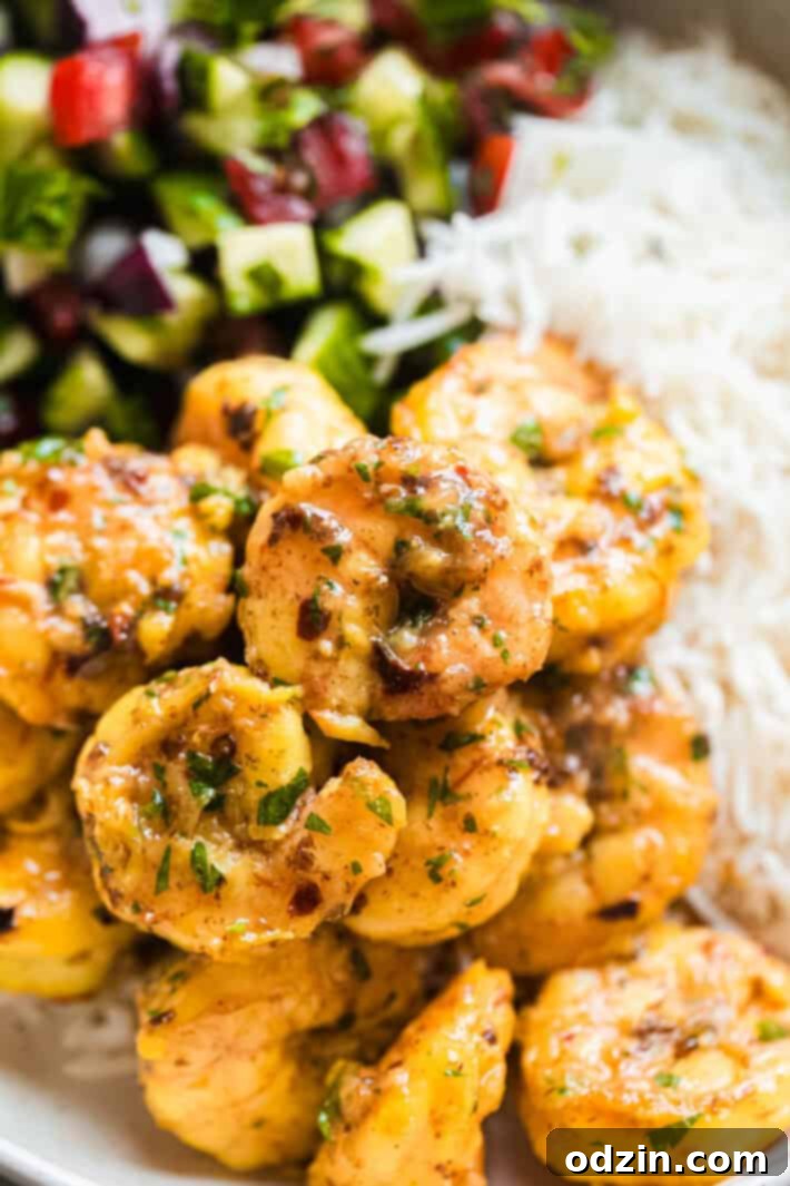 Close-up of perfectly cooked shrimp generously coated in a rich saffron butter sauce, glistening under soft light.
