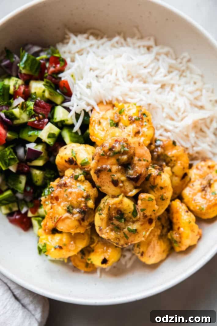 Plated saffron shrimp with fluffy basmati rice and a side of fresh Shirazi salad, ready to be enjoyed.