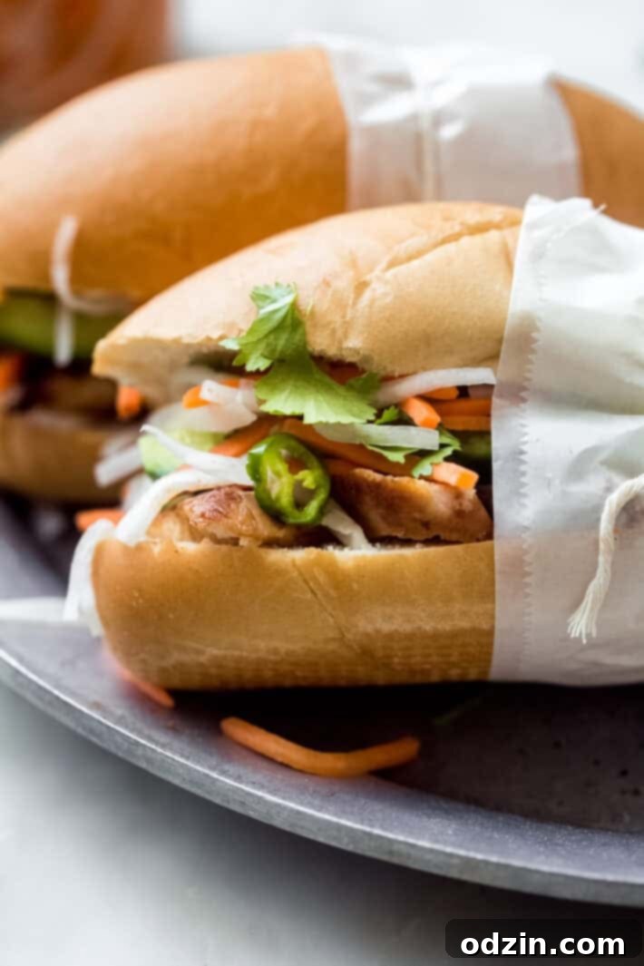 Close-up view of a completed chicken Banh Mi sandwich, highlighting the layers of filling.