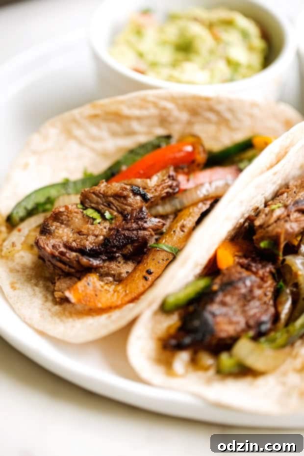 Sizzling Steak Fajita Perfection 6 thinly sliced steak fajitas with colored peppers and onions on tortillas