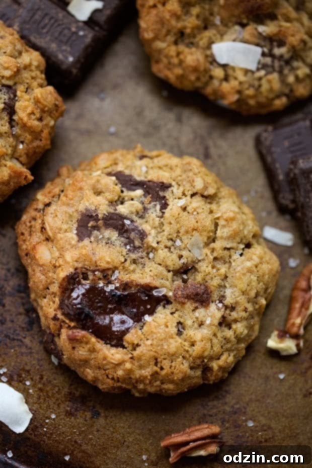 Freshly Baked Loaded Dark Chocolate Chip Oatmeal Cookies A stack of loaded dark chocolate chip oatmeal cookies on a cooling rack