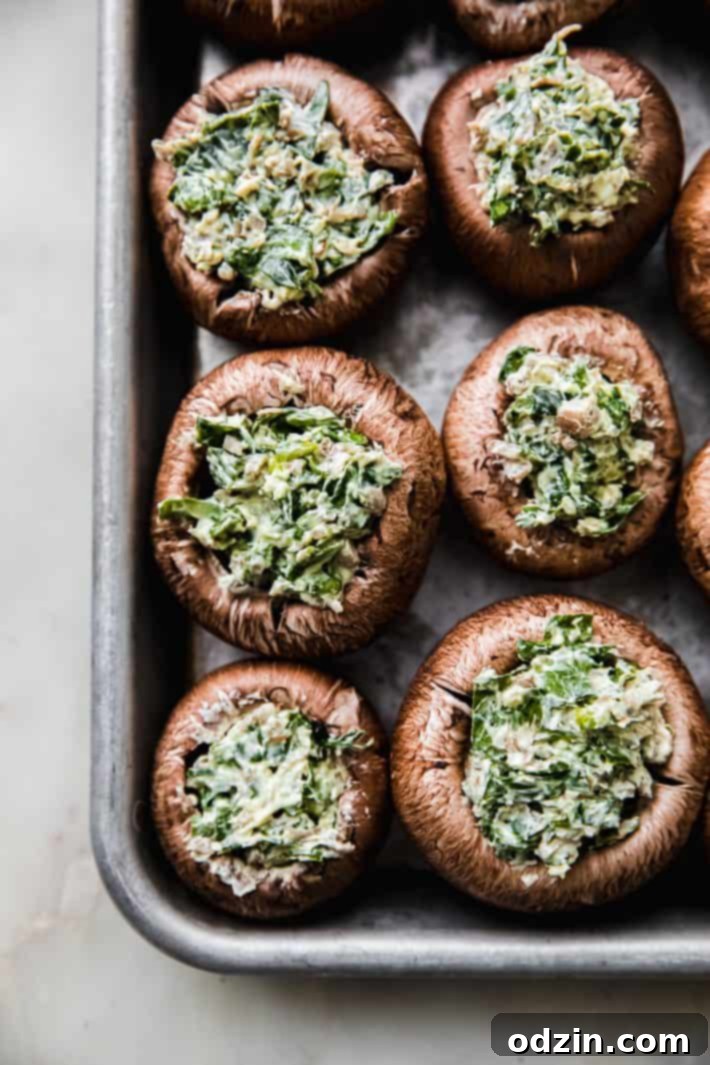stuffed mushroom caps in baking sheet before topping