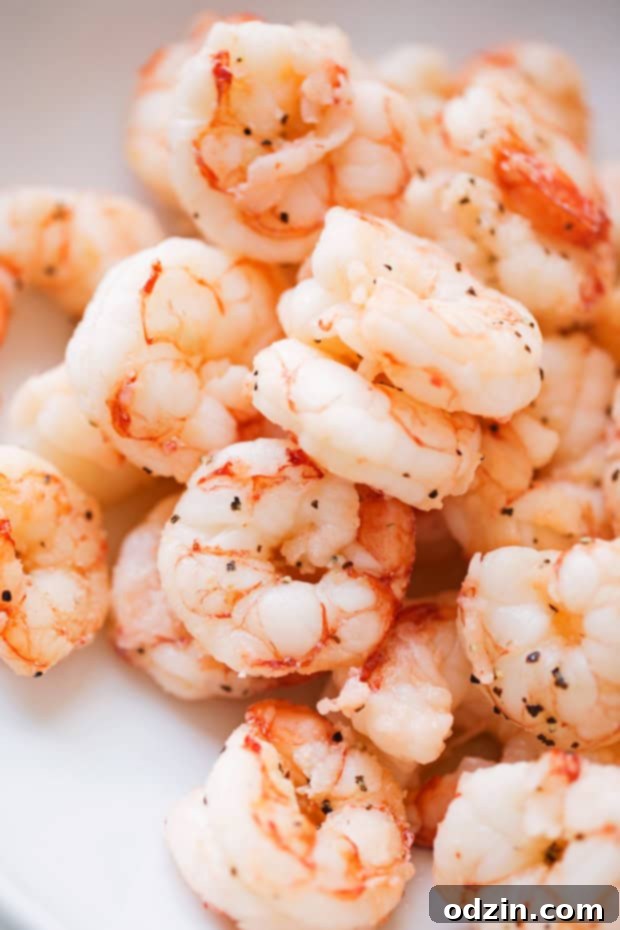 Shrimp Enchiladas with Creamy Poblano Sauce - Simple and delicious shrimp enchiladas stuffed with fresh baby spinach and matchstick carrots. Then drizzle with the creamiest cheese and poblano sauce! #shrimpenchiladas #enchiladas #seafoodenchiladas #mexicanfood | Littlespicejar.com @Littlespicejar cooked shrimp in bowl