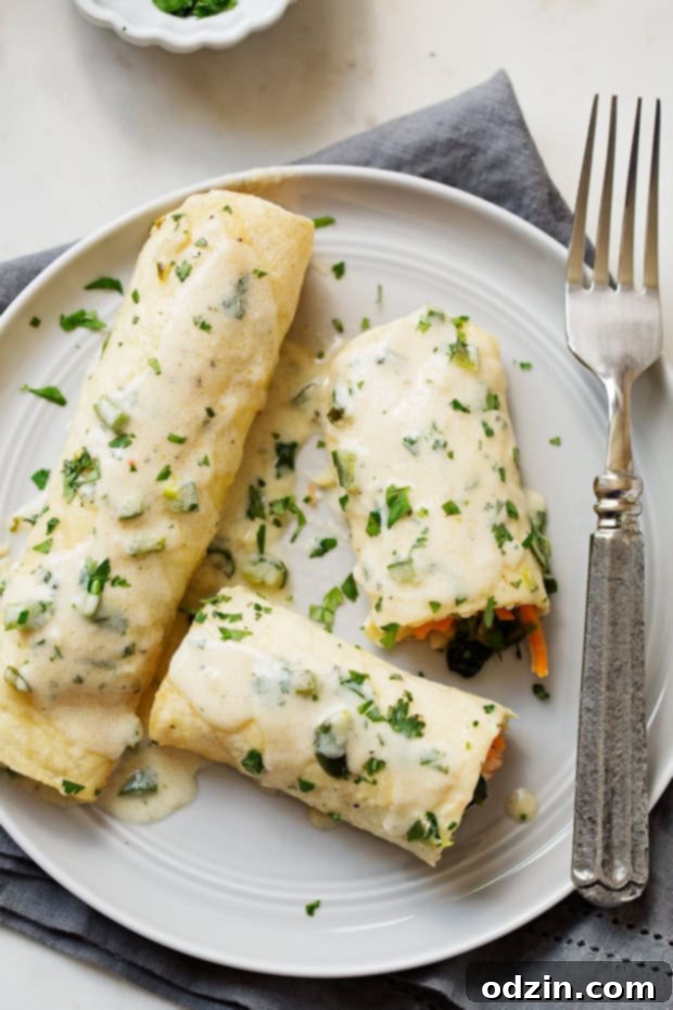 Shrimp Enchiladas with Creamy Poblano Sauce - Simple and delicious shrimp enchiladas stuffed with fresh baby spinach and matchstick carrots. Then drizzle with the creamiest cheese and poblano sauce! #shrimpenchiladas #enchiladas #seafoodenchiladas #mexicanfood | Littlespicejar.com @Littlespicejar enchiladas on plate with fork