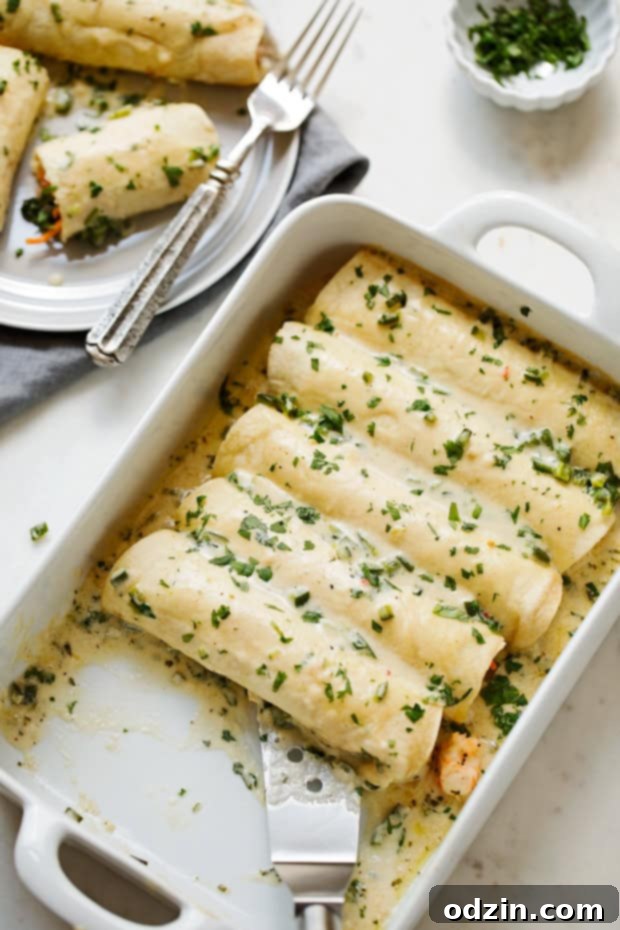 Shrimp Enchiladas with Creamy Poblano Sauce - Simple and delicious shrimp enchiladas stuffed with fresh baby spinach and matchstick carrots. Then drizzle with the creamiest cheese and poblano sauce! #shrimpenchiladas #enchiladas #seafoodenchiladas #mexicanfood | Littlespicejar.com @Littlespicejar enchiladas in dish and on plate
