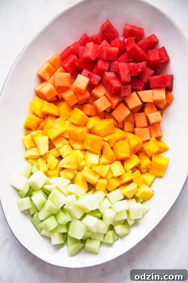 Mexican Fruit Salad - a fruit salad that combines watermelon, cantaloupe, honey dew, and mangoes that are tossed in a sweet spicy dressing! Perfect for summer! #mexicanfruit #fruitsalad #salad #mexicanfruitsalad | Littlespicejar.com