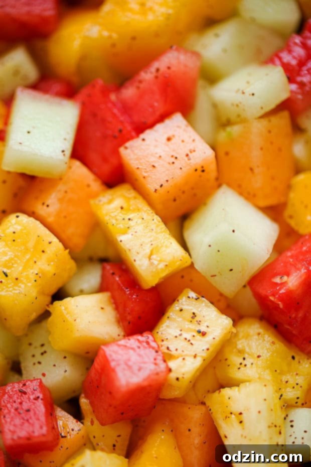 Mexican Fruit Salad - a fruit salad that combines watermelon, cantaloupe, honey dew, and mangoes that are tossed in a sweet spicy dressing! Perfect for summer! #mexicanfruit #fruitsalad #salad #mexicanfruitsalad | Littlespicejar.com