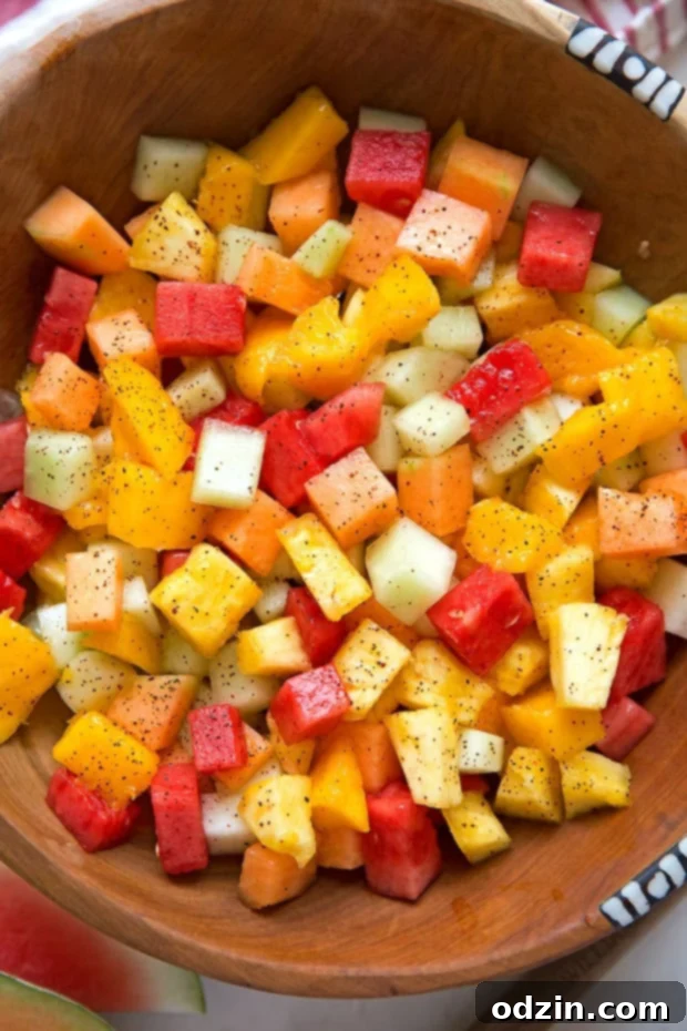 Mexican Fruit Salad - a fruit salad that combines watermelon, cantaloupe, honey dew, and mangoes that are tossed in a sweet spicy dressing! Perfect for summer! #mexicanfruit #fruitsalad #salad #mexicanfruitsalad | Littlespicejar.com