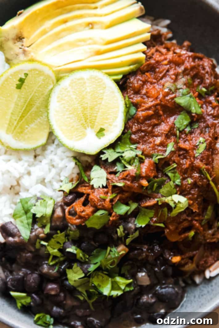 Melt-in-Your-Mouth Cuban Ropa Vieja 6 Platter of Ropa Vieja with a side of rice and beans, ready for family style serving.
