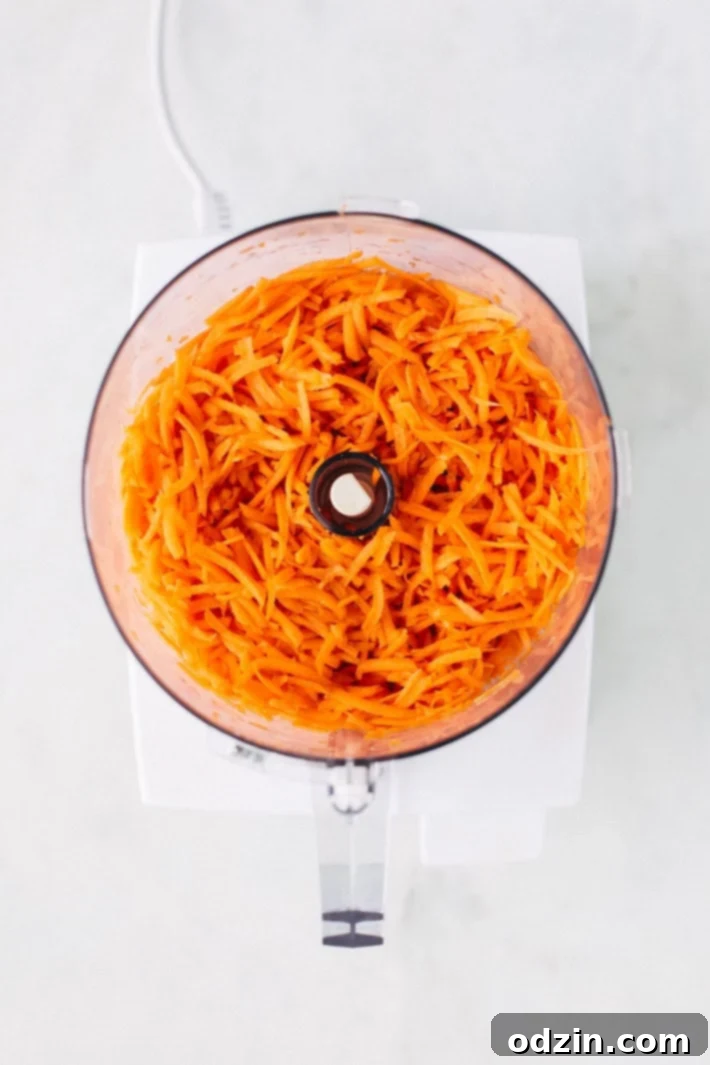 A batch of freshly baked, Super Moist and Healthy Carrot Cake Muffins cooling on a rack, highlighting their golden tops and rustic oat sprinkle. From Littlespicejar.com