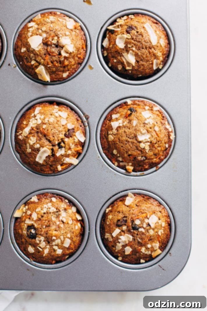A close-up shot of the perfectly baked, golden-brown tops of Super Moist and Healthy Carrot Cake Muffins, ready to be enjoyed. From Littlespicejar.com