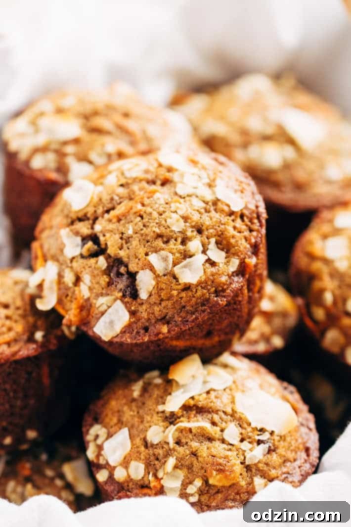 A beautifully arranged serving of Super Moist and Healthy Carrot Cake Muffins, garnished with a sprinkle of oats, ready to be enjoyed. From Littlespicejar.com