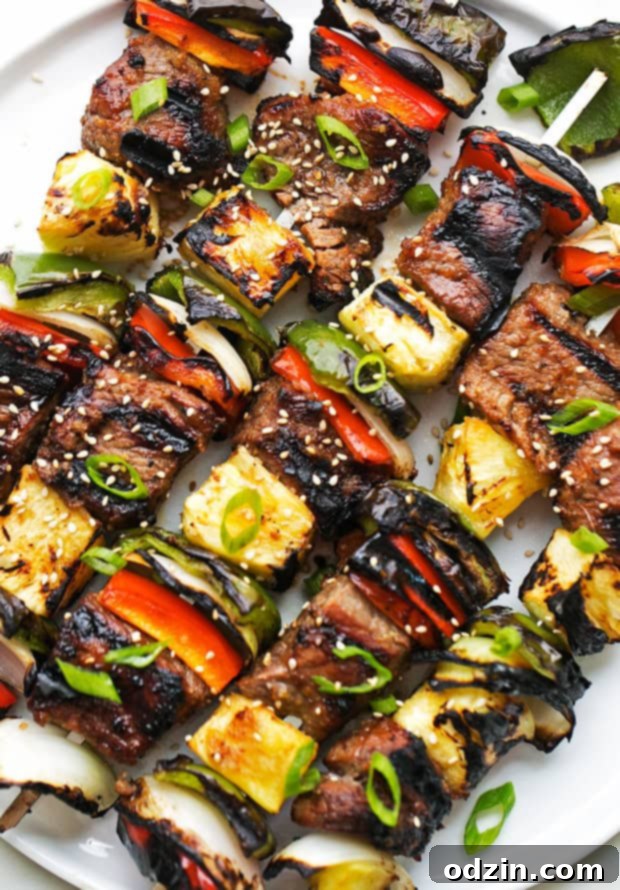 Perfectly Grilled Korean Beef Kabobs: Easy Bulgogi Recipe A stunning close-up of finished Korean Beef Kabobs (Bulgogi) on skewers, garnished with sesame seeds and fresh scallions, ready to be enjoyed.