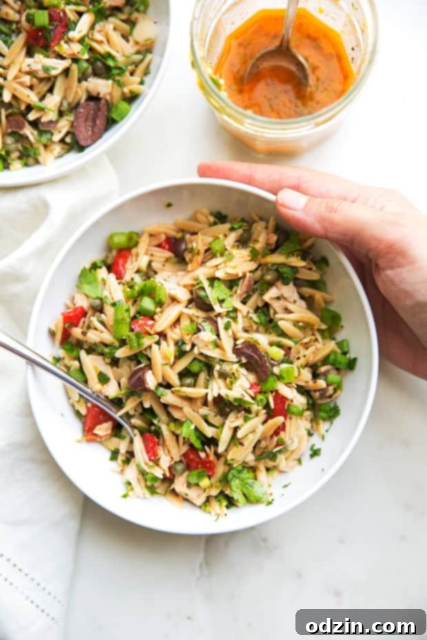Close-up of fresh Mediterranean Tuna Orzo Summer Salad with capers, olives, and parsley