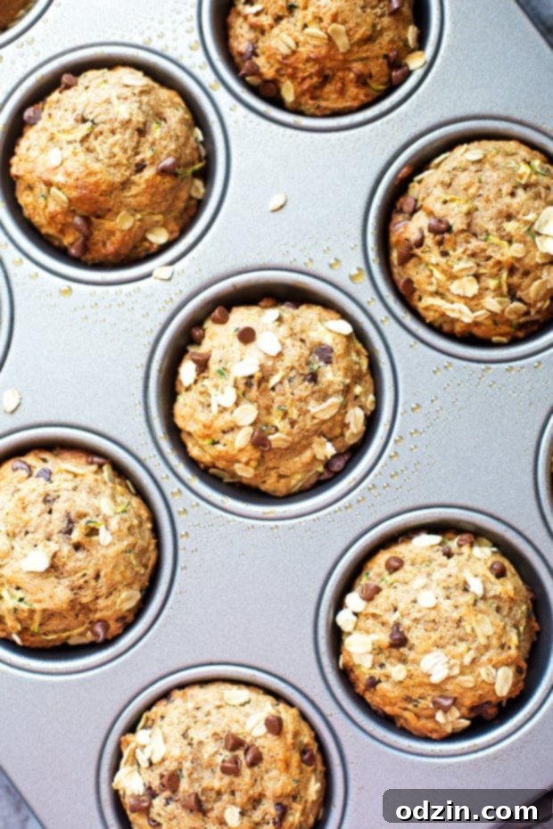 Healthy Zucchini Muffins with Chocolate Chips - Slice of a muffin showing moist texture and chocolate chips.