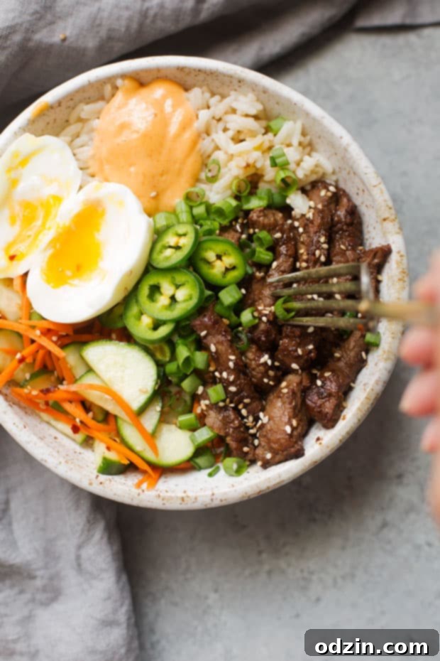 Korean BBQ Bowls with Garlic Scented Rice - Warm, comforting bowls with marinated steak, garlic rice, and a pickled cucumber salad. It's seriously amazing! #koreanbbqbowls #bowls #garlicrice | Littlespicejar.com