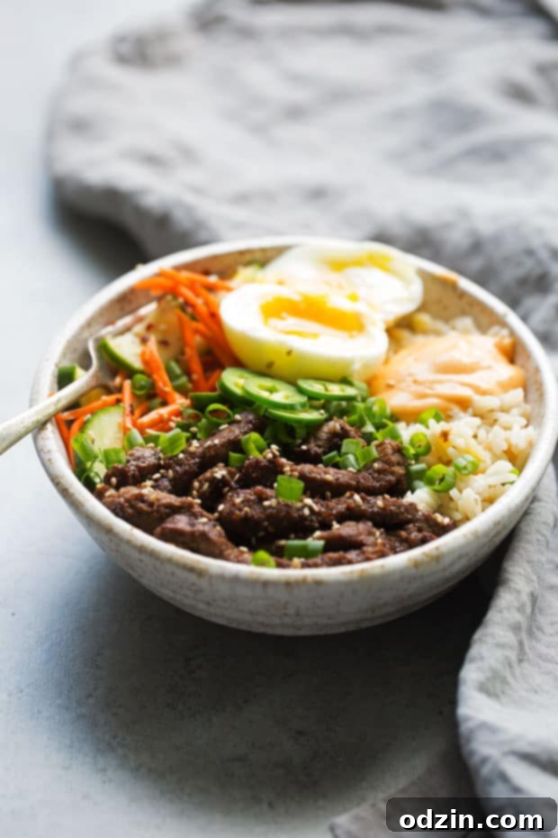 Korean BBQ Bowls with Garlic Scented Rice - Warm, comforting bowls with marinated steak, garlic rice, and a pickled cucumber salad. It's seriously amazing! #koreanbbqbowls #bowls #garlicrice | Littlespicejar.com
