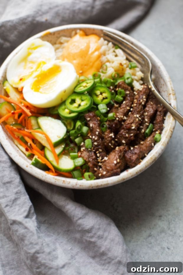 Korean BBQ Bowls with Garlic Scented Rice - Warm, comforting bowls with marinated steak, garlic rice, and a pickled cucumber salad. It's seriously amazing! #koreanbbqbowls #bowls #garlicrice | Littlespicejar.com