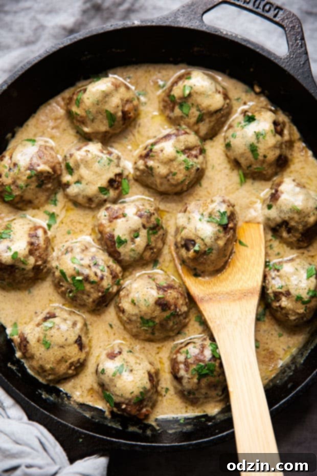 cast iron skillet with Swedish meatballs covered in brown cream sauce