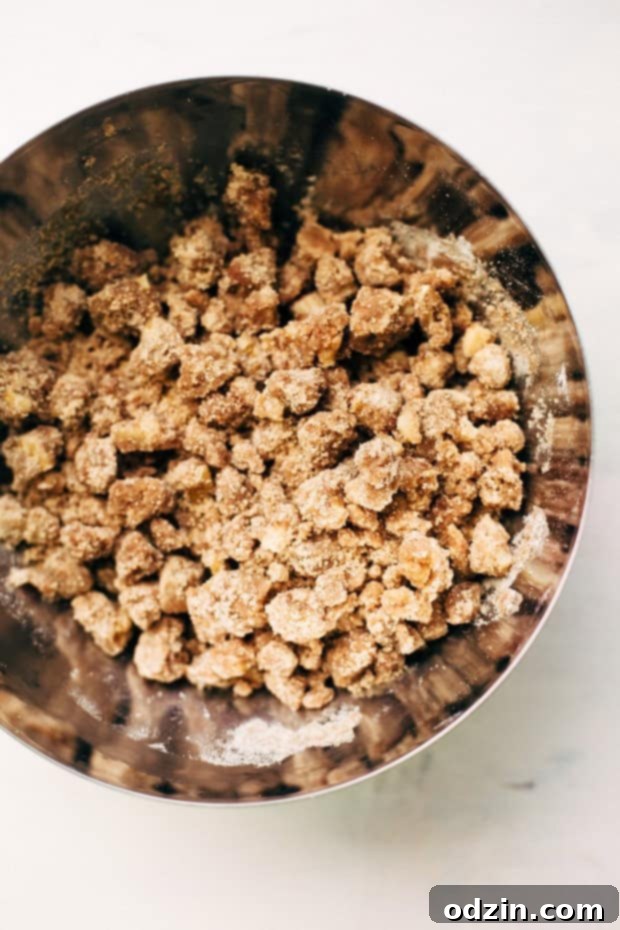 Cinnamon Apple Crumb Cake - A simple coffee cake topped with sliced apples and lots of jump lump crumbs. The perfect accompaniment to coffee of a crisp fall morning! #coffeecake #applecrumbcake #crumbcake | Littlespicejar.com Cinnamon Apple Crumb Cake from an aerial view, showcasing the delicious streusel.