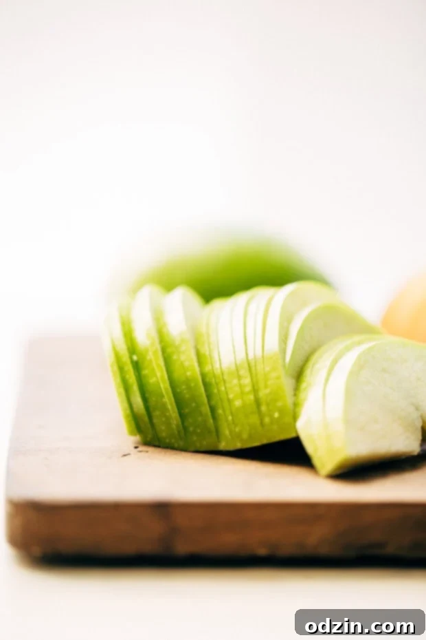 Cinnamon Apple Crumb Cake - A simple coffee cake topped with sliced apples and lots of jump lump crumbs. The perfect accompaniment to coffee of a crisp fall morning! #coffeecake #applecrumbcake #crumbcake | Littlespicejar.com Side profile of baked Cinnamon Apple Crumb Cake, showing layers of cake, apples, and streusel.