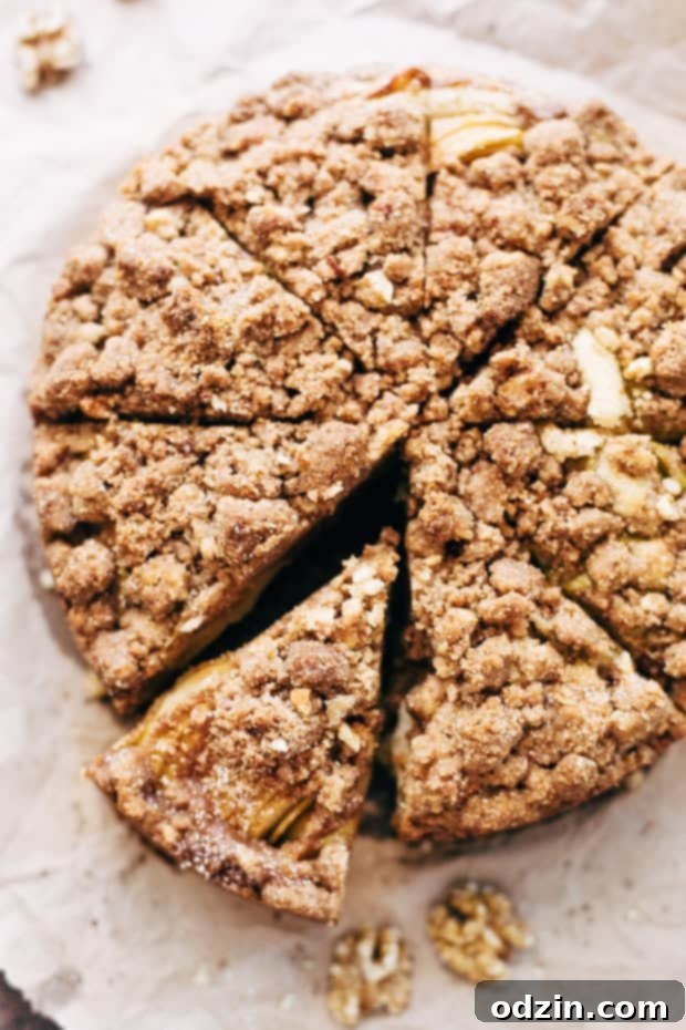 Cinnamon Apple Crumb Cake - A simple coffee cake topped with sliced apples and lots of jump lump crumbs. The perfect accompaniment to coffee of a crisp fall morning! #coffeecake #applecrumbcake #crumbcake | Littlespicejar.com A slice of Cinnamon Apple Crumb Cake, revealing its moist interior and apple layers.