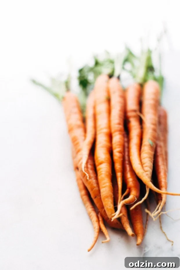 Tender honey glazed carrots seasoned with herbs, glistening after roasting, a perfect holiday side dish.
