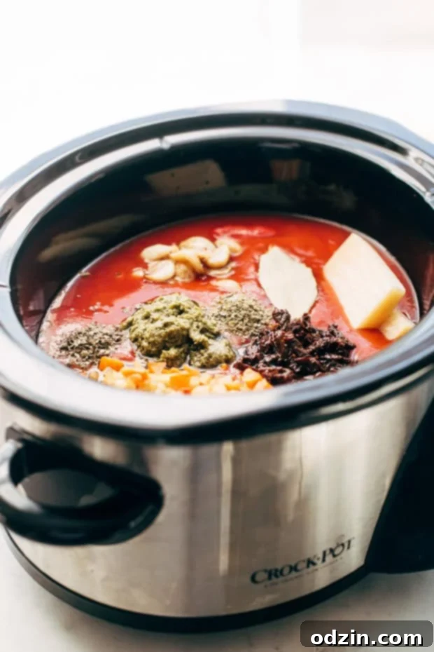 Close-up of creamy tomato soup topped with fresh basil and grated Parmesan cheese. #homemadesoup #slowcookertomatosoup