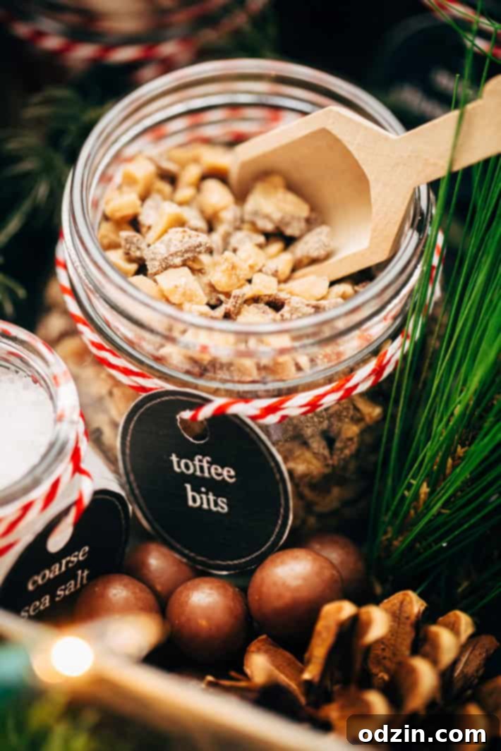 DIY Hot Chocolate Bar Party - Learn how to set up your own hot chocolate bar! Tons of printables, decorating ideas, and toppings! Plus, the most luxurious hot chocolate recipe! #hotchocolate #hotchocolatebar #diyhotchocolatebar #slowcooker | Littlespicejar.com toffee bits in mason jar with label and wooden scoop