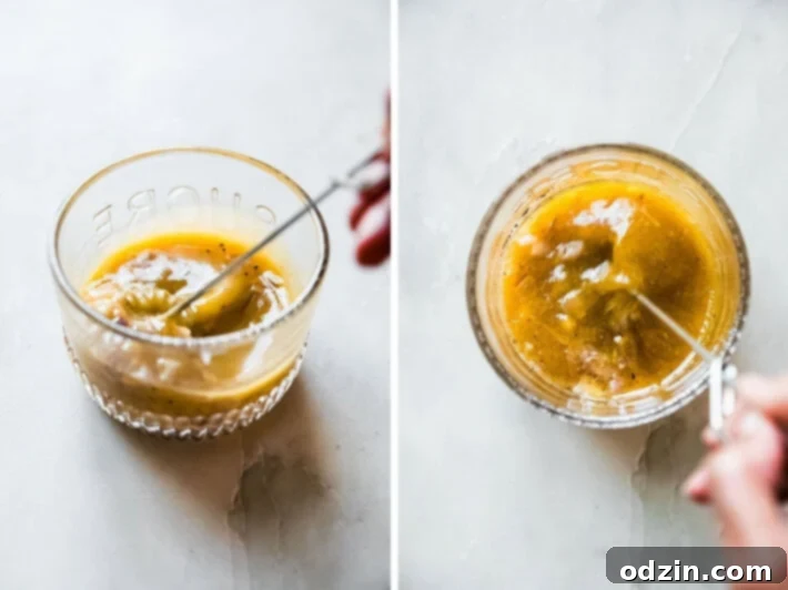 Preparing the homemade salad dressing, with a whisk stirring vibrant ingredients like orange juice, apple cider vinegar, and shallots in a clear glass container